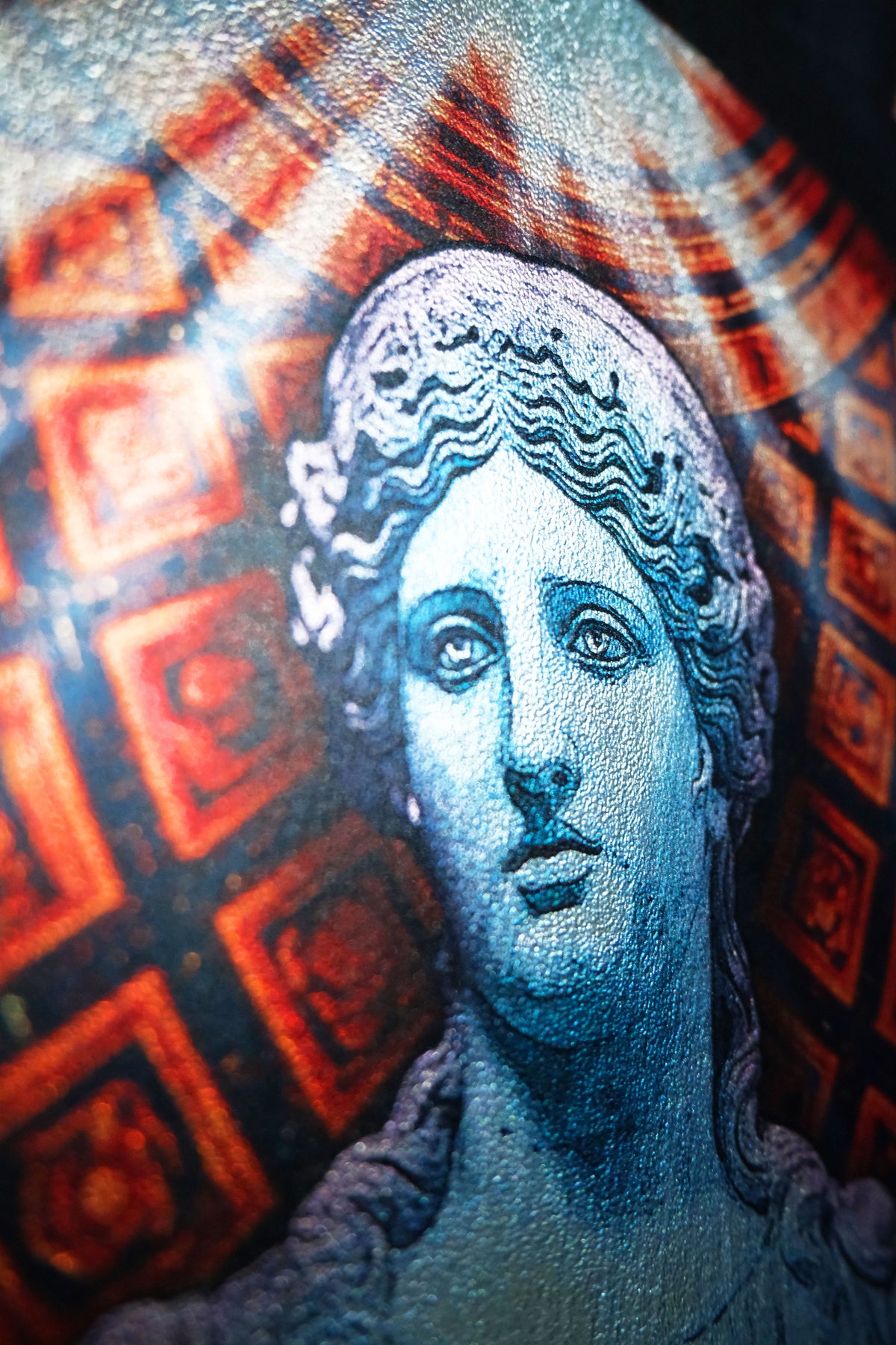 A close-up of a circular product, likely a coaster or decorative plate, featuring a blue-toned classical bust portrait of a woman against a red and black patterned background.dark academia decor Melpomene
Muse of Tragedy