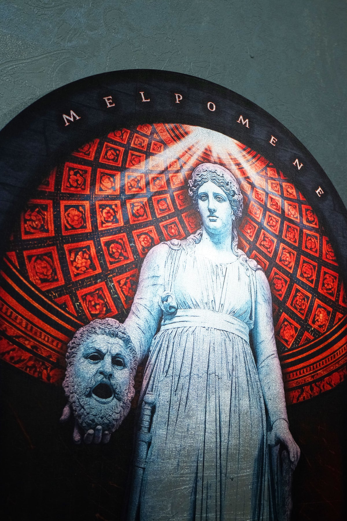 A circular wall art piece featuring a pale statue of Melpomene holding a dramatic red patterned backdrop and a gray theatrical mask, set against a dark background.dark academia decor Melpomene
Muse of Tragedy
