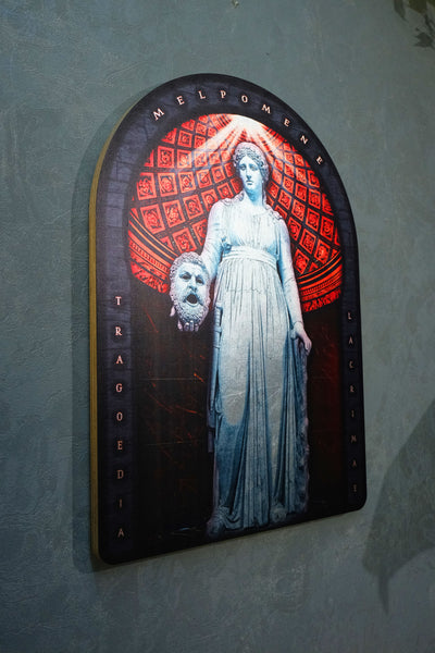 An arched decorative wall plaque featuring a classical statue of Medusa with a severed head, set against a red patterned background and mounted on a textured gray wall.dark academia decor  Melpomene
Muse of Tragedy