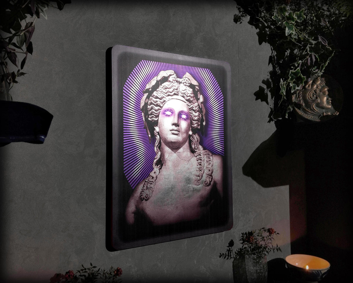 Decorative wall art with a stylized portrait in a frame on a dark background
"Dionysus silver leaf wall art with purple glow accents in dark modern frame"
